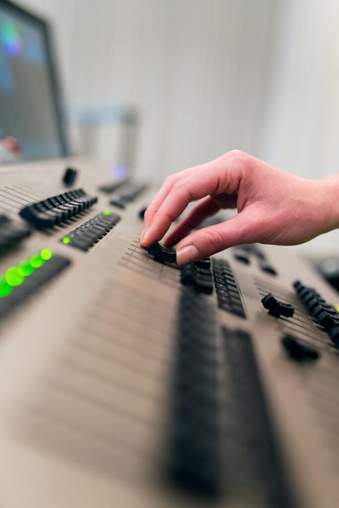 pexels photo 3862607 A hand adjusting sliders and knobs on a professional sound mixing console.